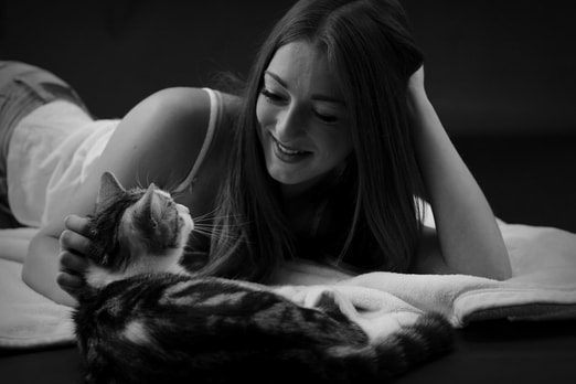 Smiling woman looks into a cat's eyes